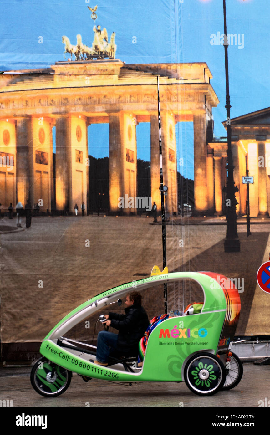 Taxi tricycle Berlin devant la Brandenburger Tor comme peint sur matériel pour couvrir un chantier Banque D'Images