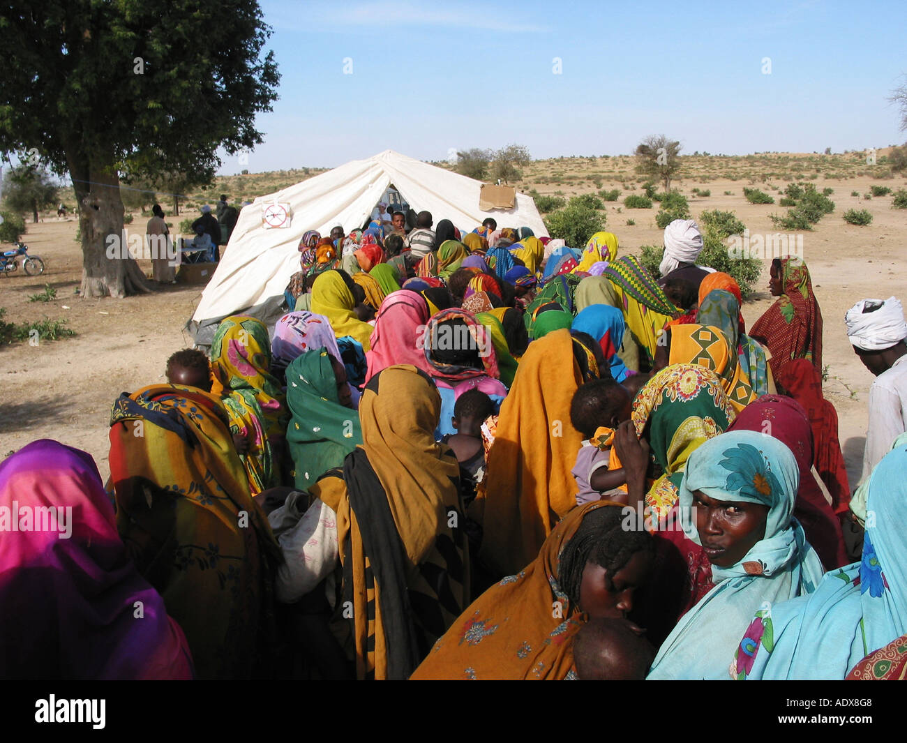 Les personnes déplacées à l'aller avec leurs enfants à obtenir des soins de santé et de vaccination contre la rougeole lors d'une clinique de MSF à l'Adre Tchad Banque D'Images