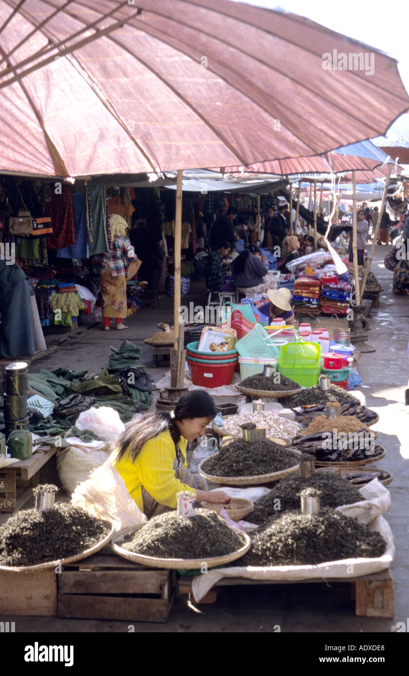 Décrochage du marché tous les jours à produire pour la vente à l'ombre d'un parapluie rose en Birmanie Myanmar Banque D'Images