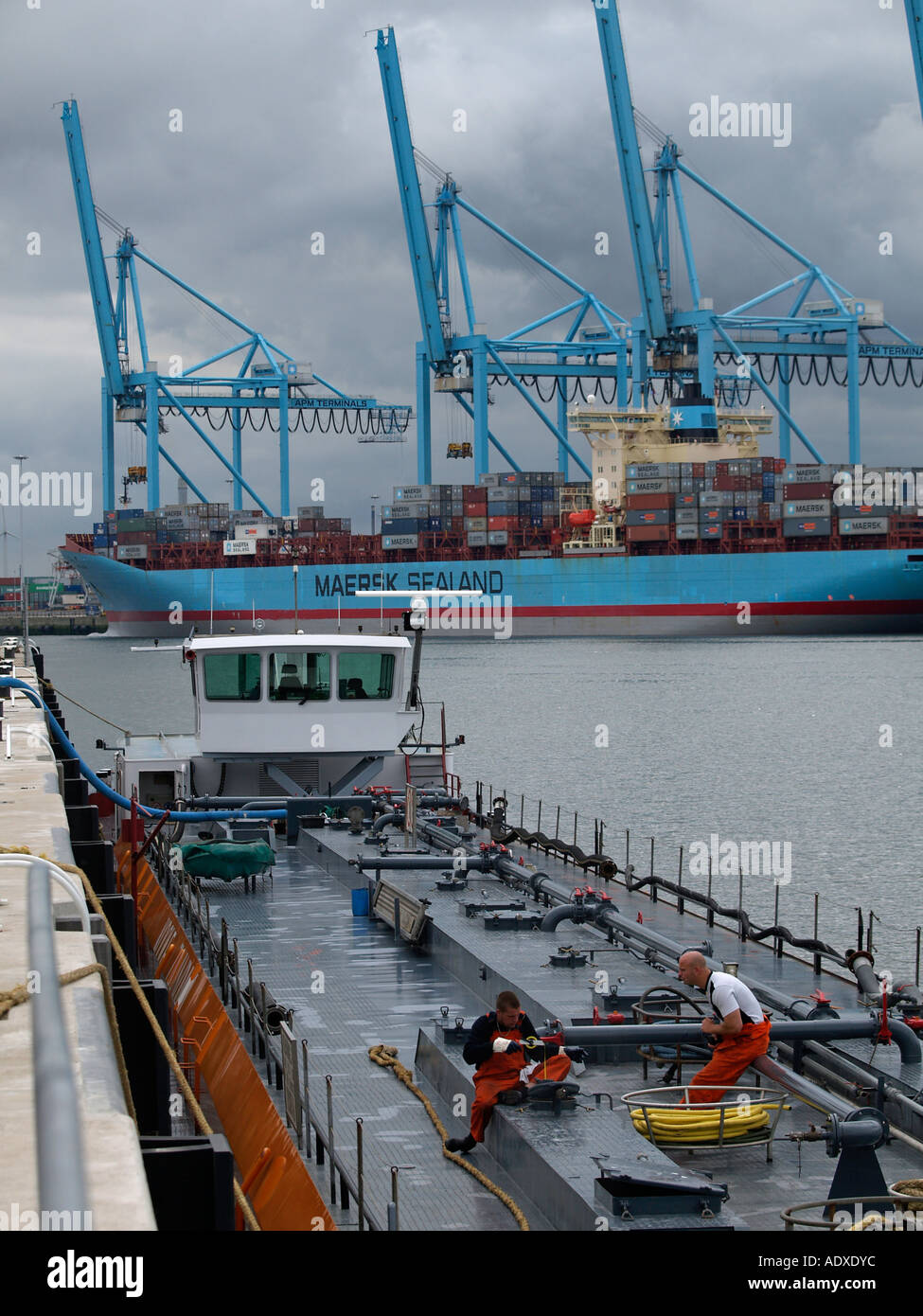 Deux hommes travaillant sur le pont d'un petit navire pétrolier dans le port de Rotterdam aux Pays-Bas Banque D'Images