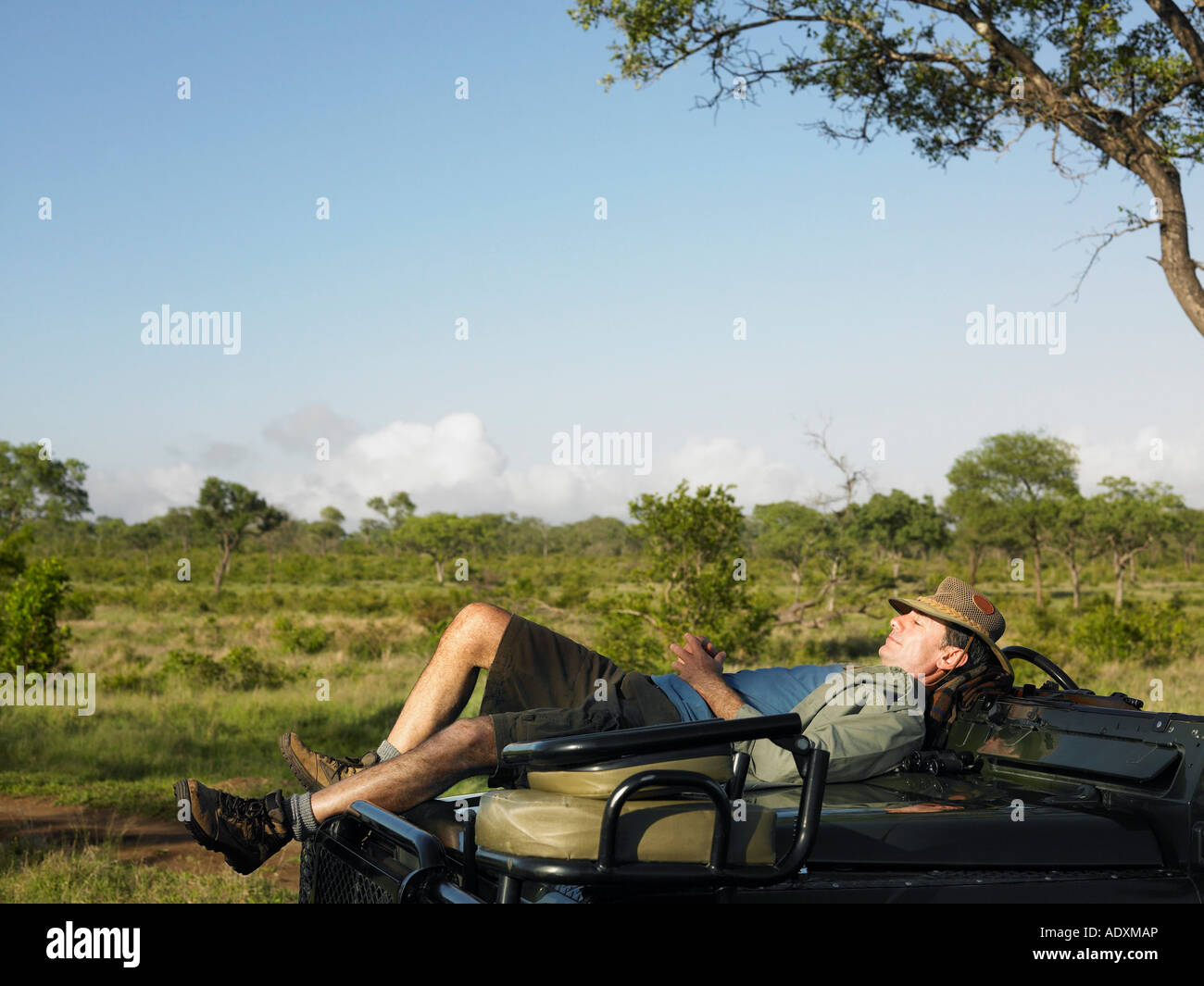Hot man lying on capot de jeep, avoir pan Banque D'Images