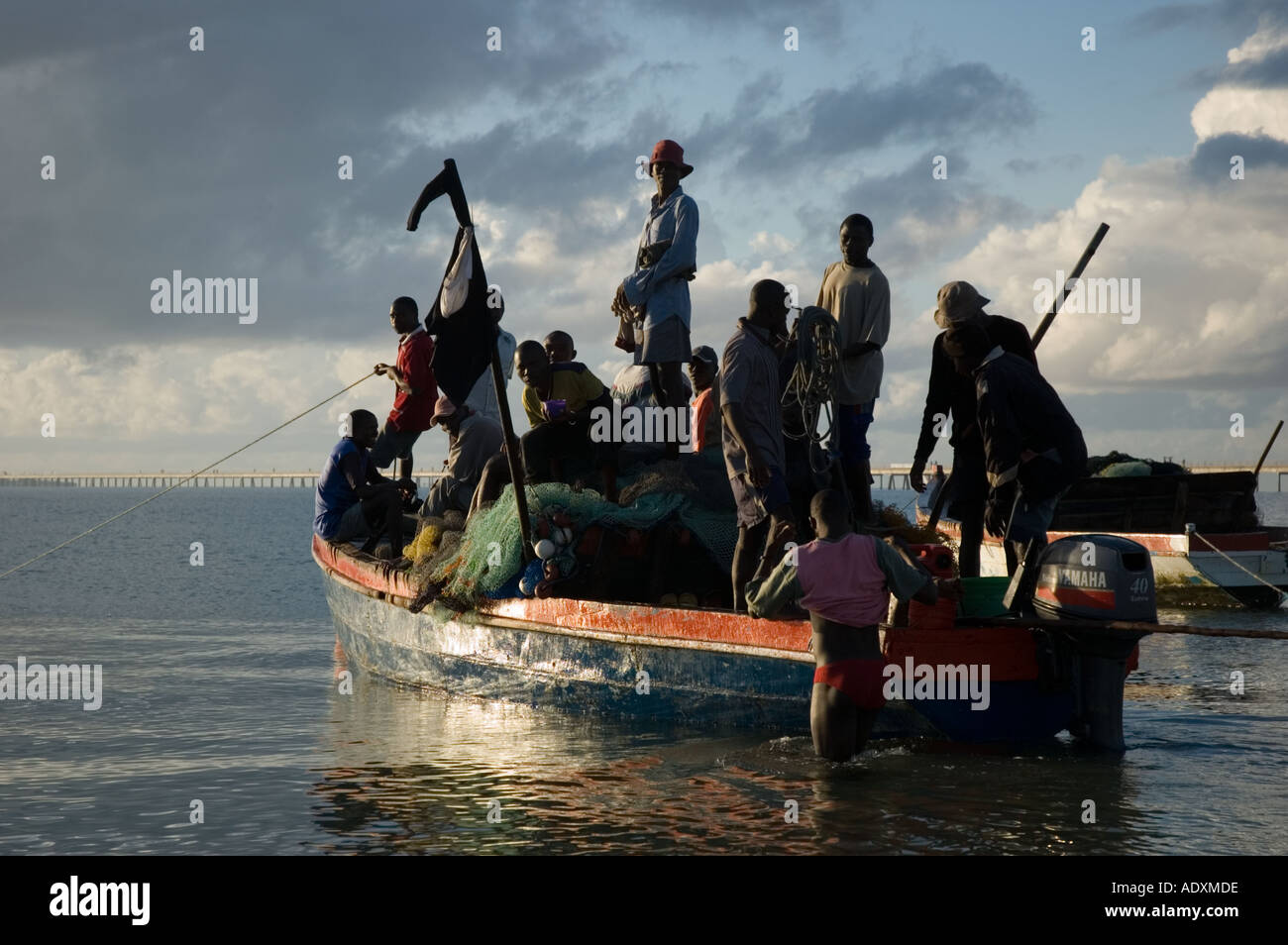 Les hommes de partir à l'île de Mozambique au travail et les poissons à l'aide d'un bateau de pêche qu'un ferry surchargé de l'Océan Indien Banque D'Images