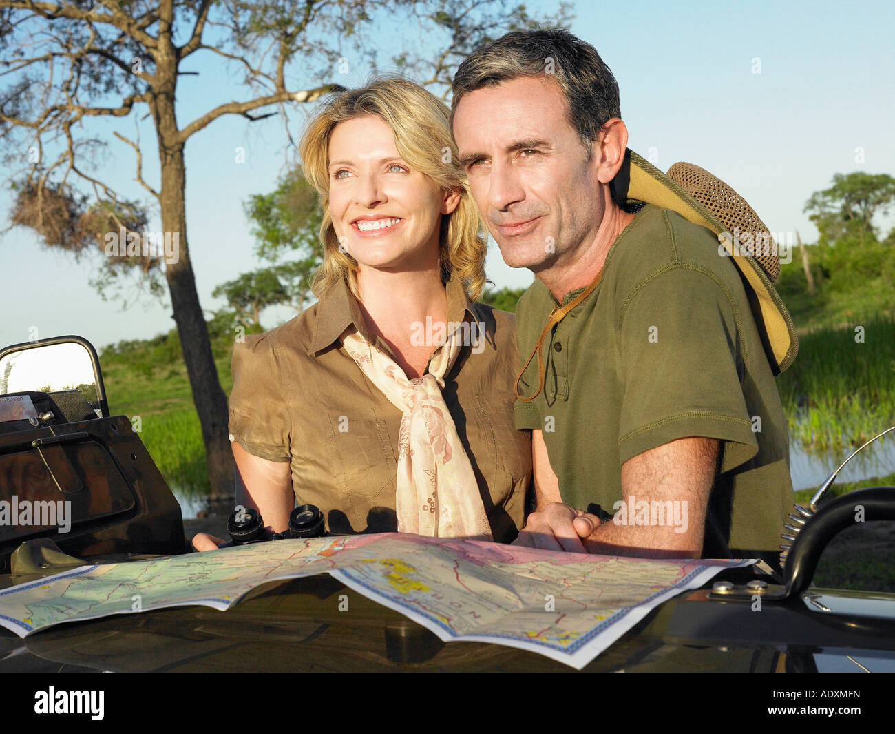 Couple looking at view, la carte se propager sur capot de jeep Banque D'Images