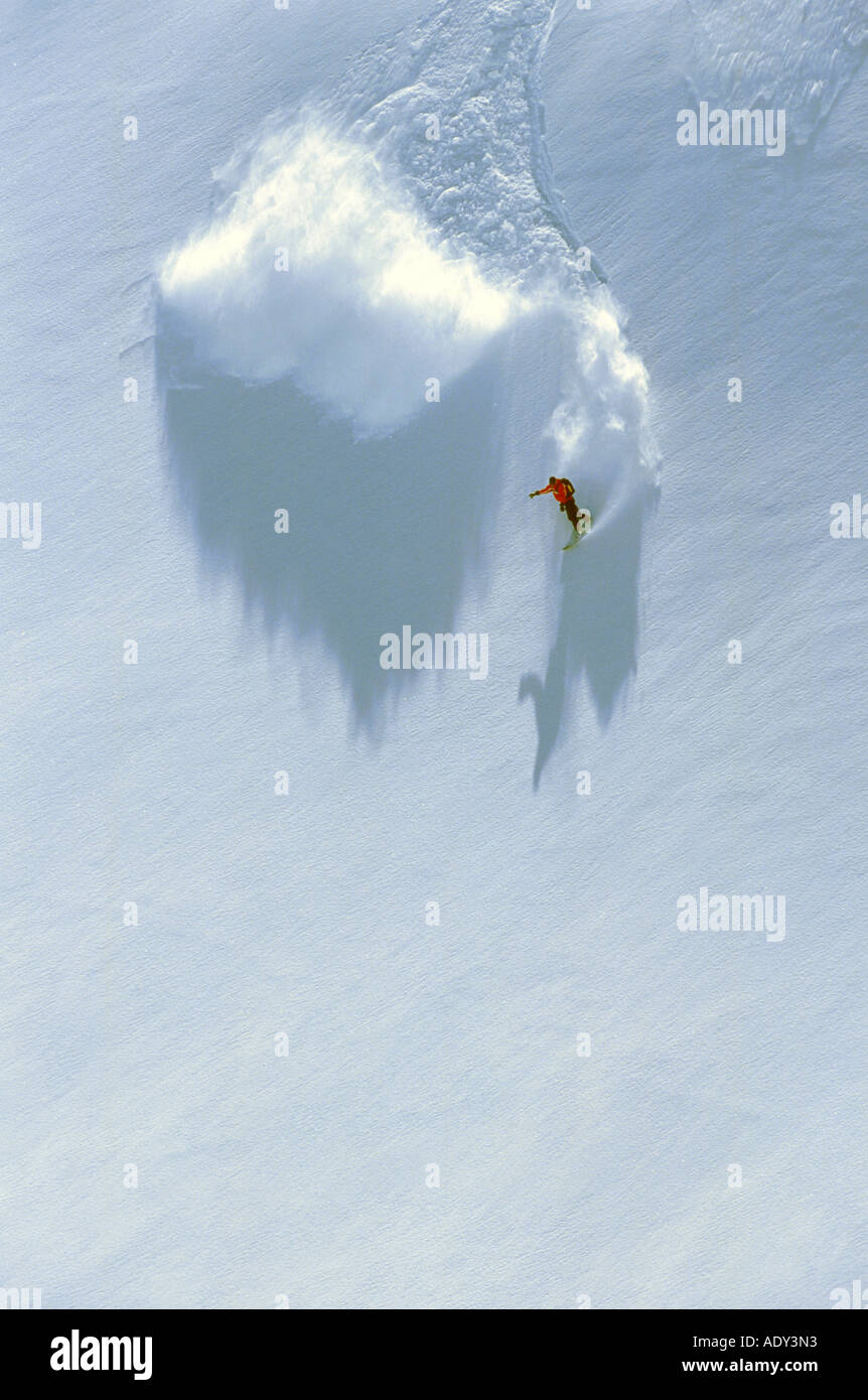 Snowboarder en pente raide, la descente dans la neige profonde, hors-pistes Banque D'Images
