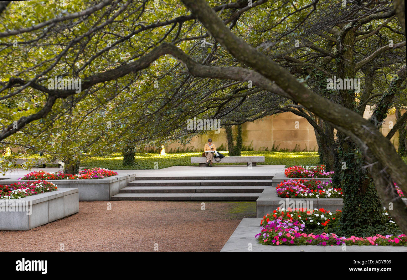 GARDENS Chicago Illinois Femme lire sur un banc de jardin au sud de l'entrée de l'Avenue Michigan Institut Art arbres fleurs Banque D'Images