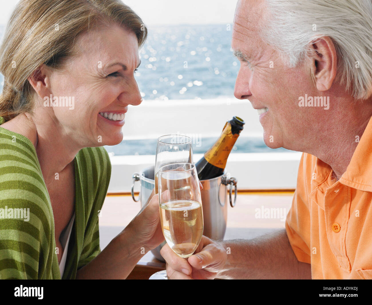 Middle-aged couple drinking champagne on yacht, side view, close-up Banque D'Images