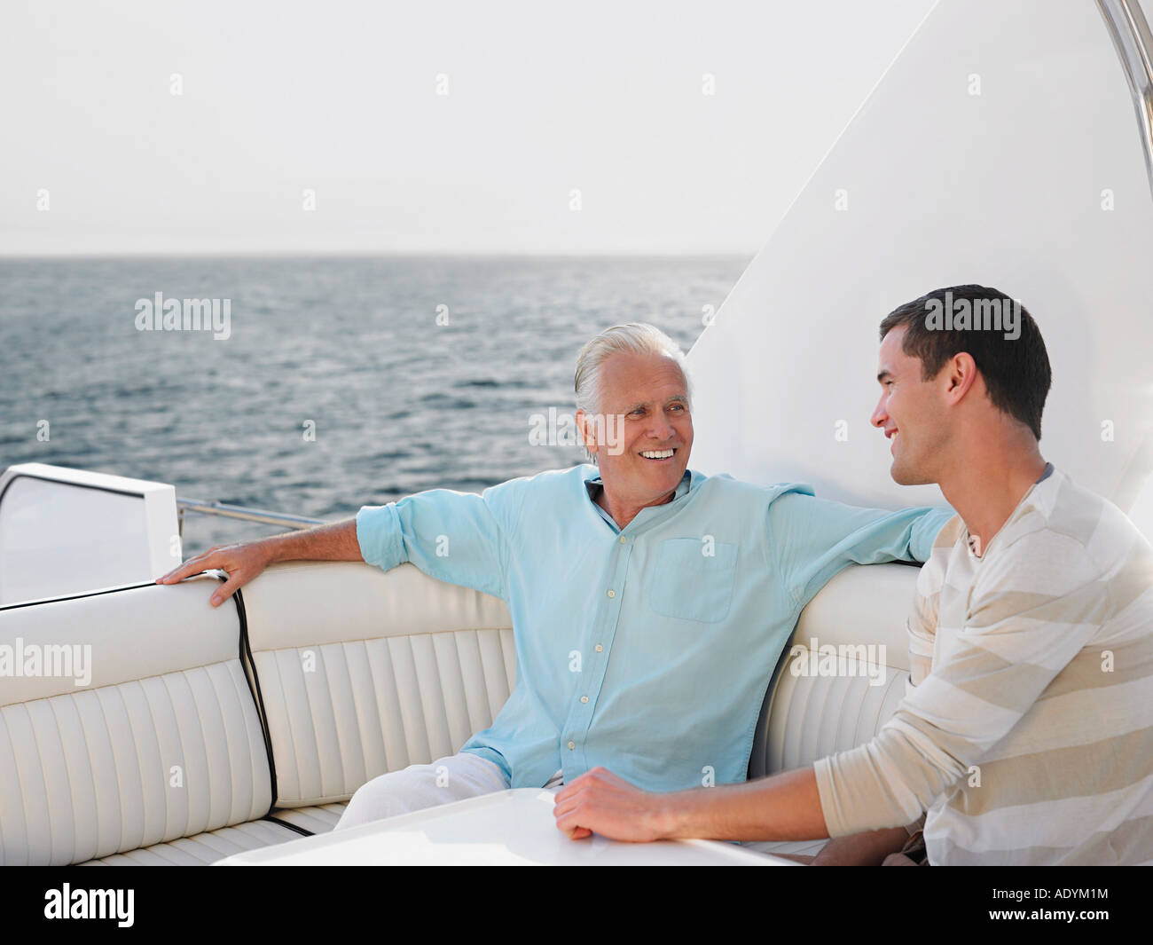 Les jeunes et d'âge moyen man talking on yacht Banque D'Images