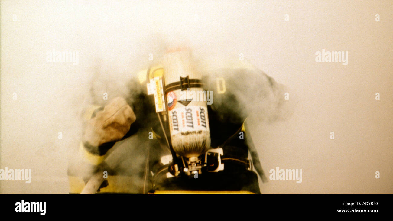 Les pompiers entre dans une pièce remplie de fumée Banque D'Images