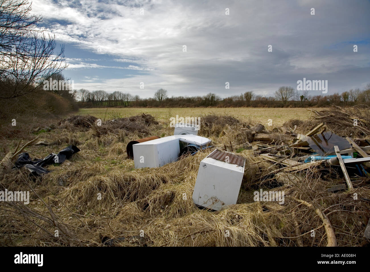 D'un réfrigérateur et lave-linge jetés dans un champ avec les autres déchets de consommation Banque D'Images