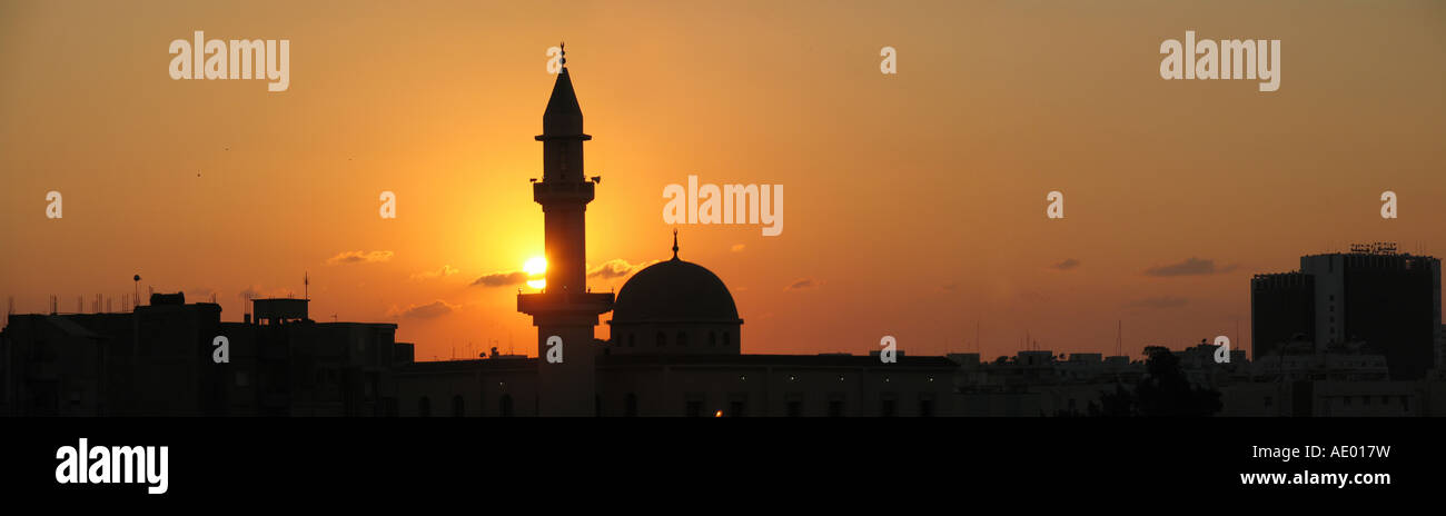 Coucher du soleil avec silhouette d'une mosquée avec minaret haut et le plus grand hôtel de Benghazi, en Libye, en Cyrénaïque, Benghazi Banque D'Images