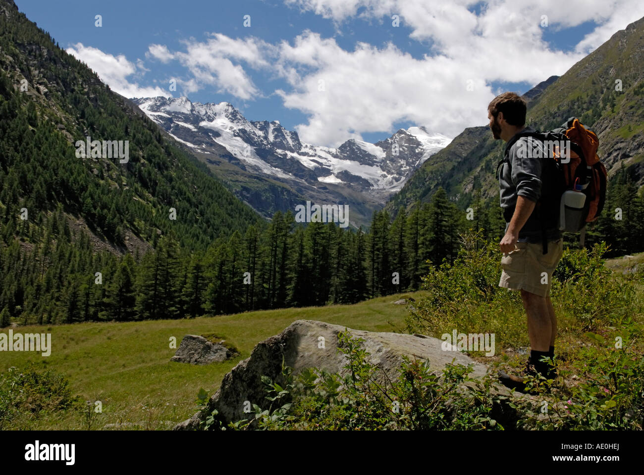 Backpacker, randonneur, homme, à la vue des Alpes, au Parc National du Gran Paradiso, Alpes Italiennes Banque D'Images