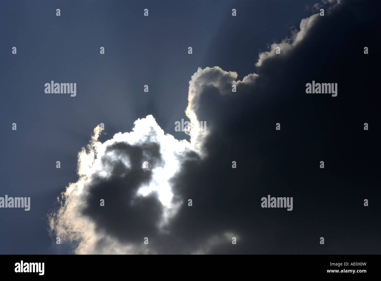 Le soleil disparaît derrière un nuage qui passe. Banque D'Images