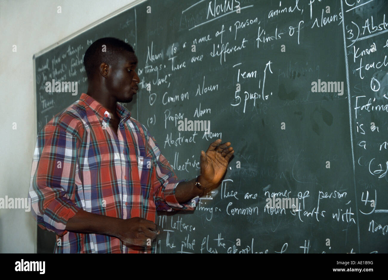 L'Afrique de l'Ouest NIGÉRIA Nigeria Kano, professeur de français à côté de donner de leçon de grammaire blackboard in classroom Banque D'Images