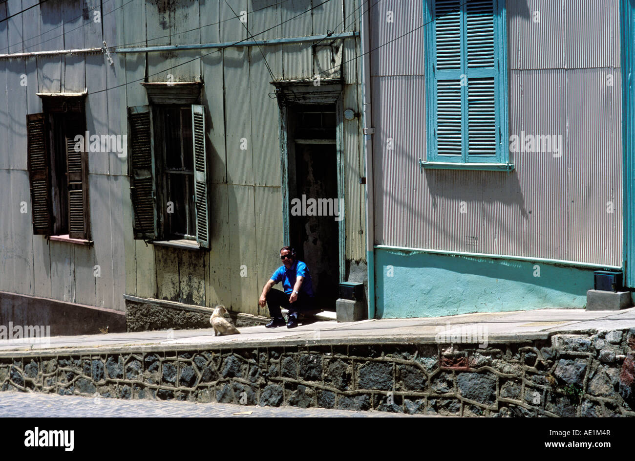 Un homme est assis sur le seuil de sa maison à Cerro Conception, Valparaiso, Chili, Amérique du Sud. Banque D'Images