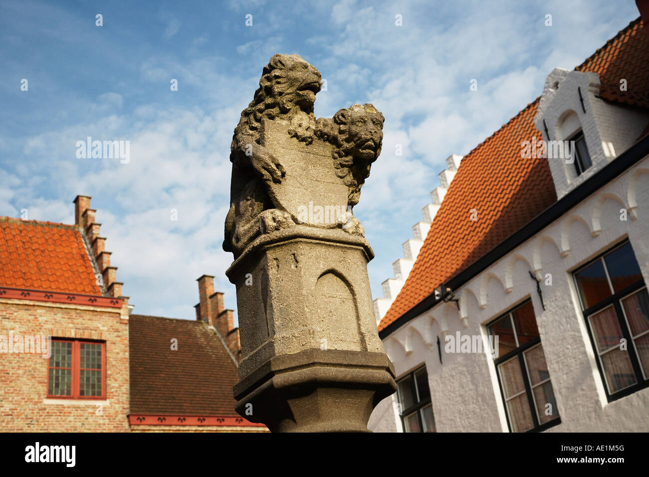La colonne surmontée d'une paire de lions avec bâtiments typiquement flamande Huidenvettersplein Bruges Belgique Banque D'Images