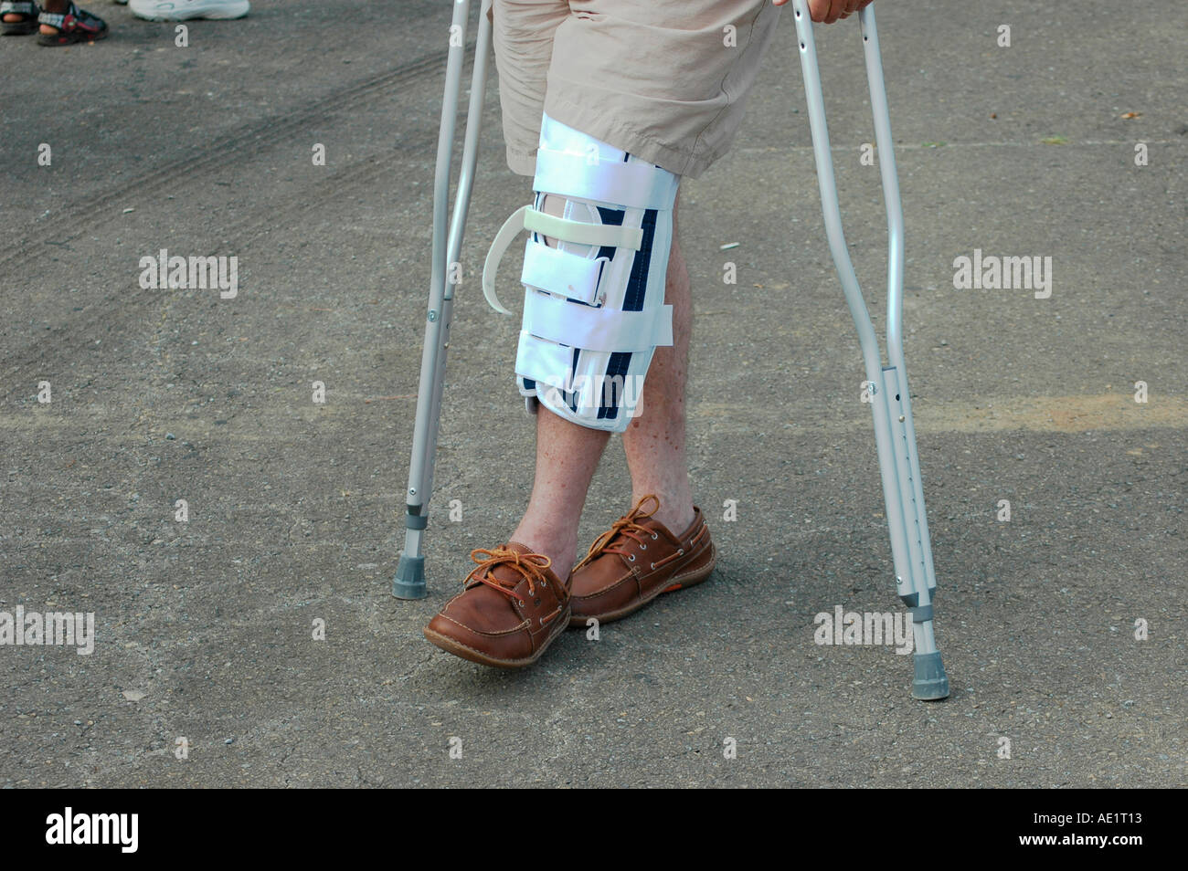 L'homme sur des béquilles à cassé réparé genou blessé marcher en ...