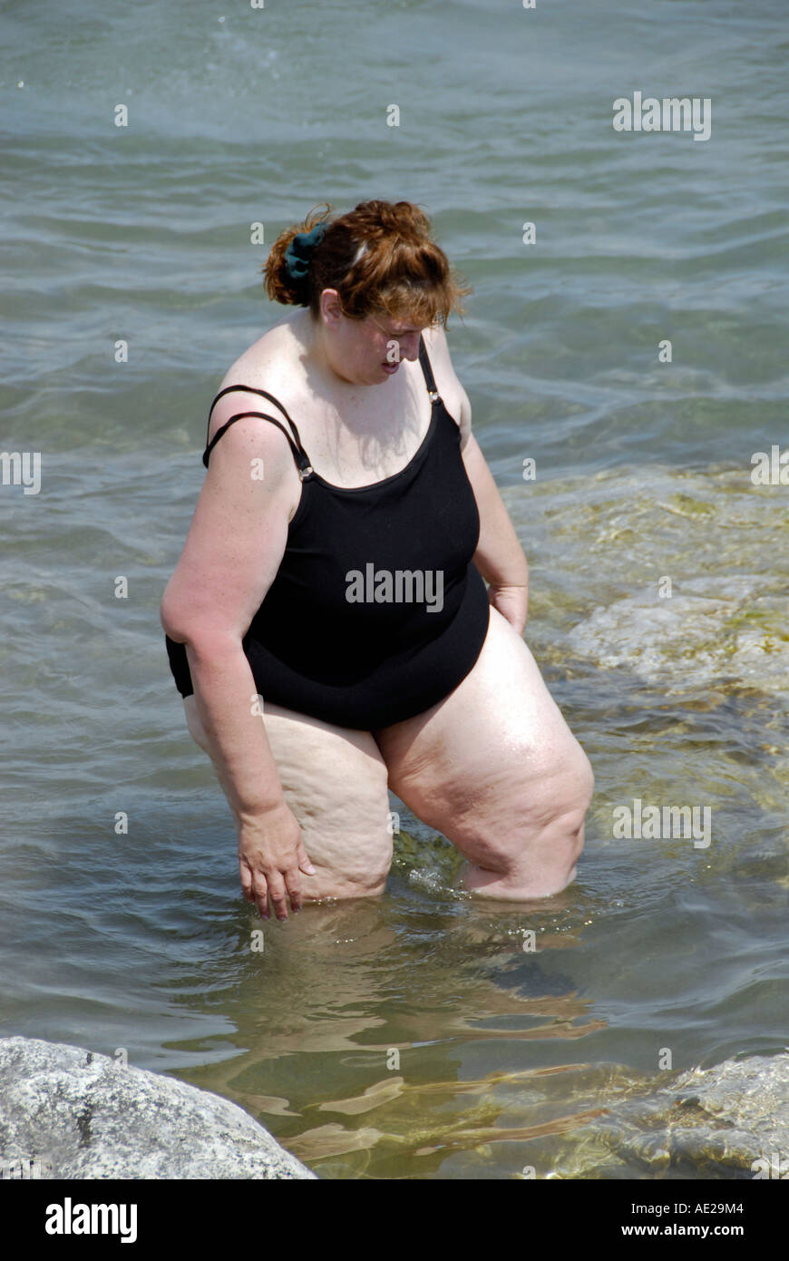 Femme obèse pataugeant dans l'eau vêtu d'un maillot de bain Photo Stock -  Alamy