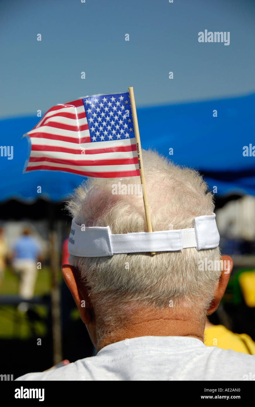 Senior male patriotique avec le drapeau américain coincé dans son pare-soleil Banque D'Images