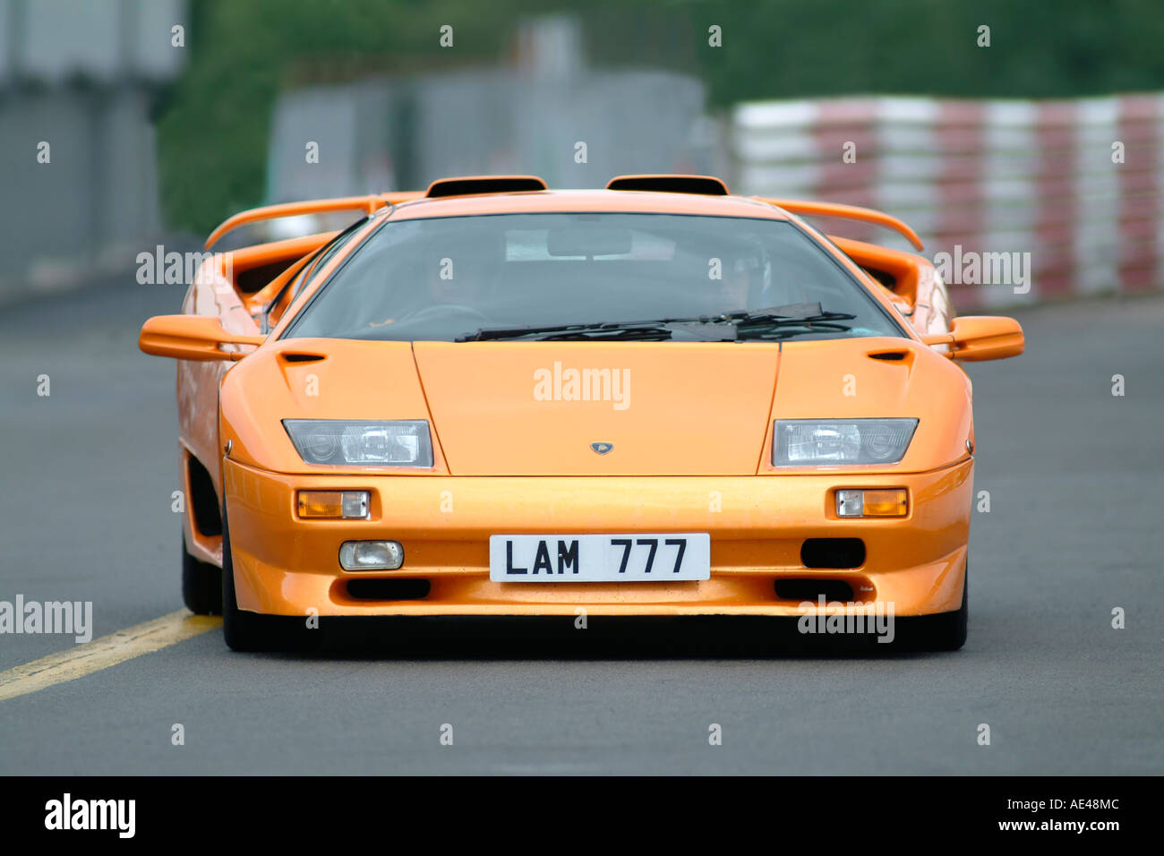 Orange Lamborghini Murcielago course de voiture de sport italienne sur une piste de course au Royaume-Uni. Banque D'Images