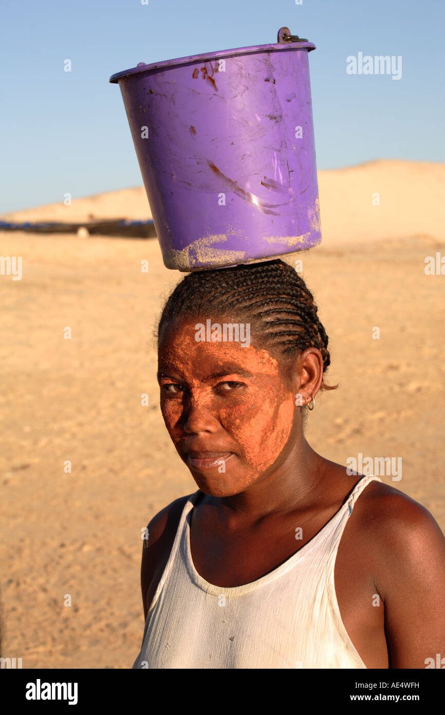 Femme avec visage peint, transportant un tronçonneur sur sa tête, Madagascar Banque D'Images