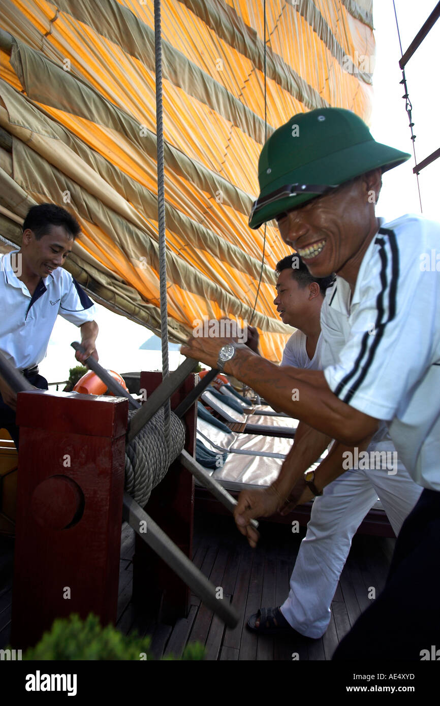 Hissant la voile sur de grandes croisières traditionnelles junk Baie de Halong Vietnam Banque D'Images