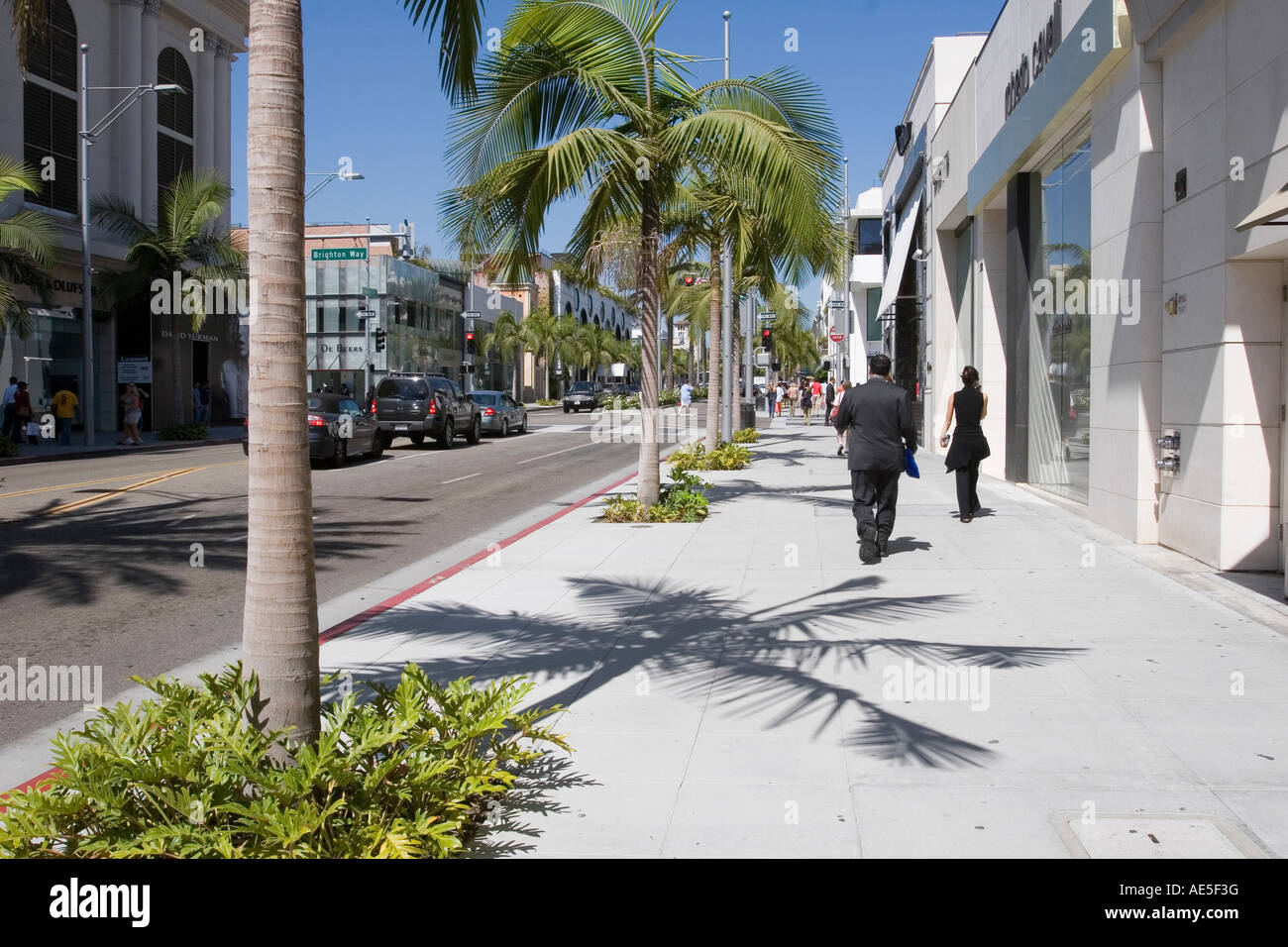 Les gens qui marchent par cher stores et de palmiers sur Rodeo Drive, Beverly Hills, Los Angeles en Californie Banque D'Images