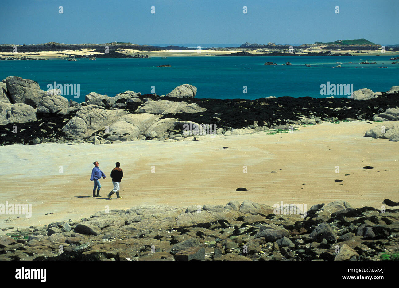 France Normandie Île Chausey Basse Normandie touristes marcher à marée basse plage Vue de côté Banque D'Images