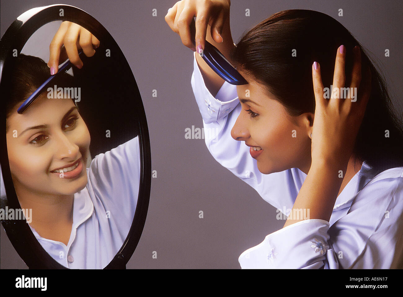 RHS70992 Fille indienne de l'Asie du Sud se coiffant avec sabot devant un miroir modèle libération Nombre 442 Banque D'Images