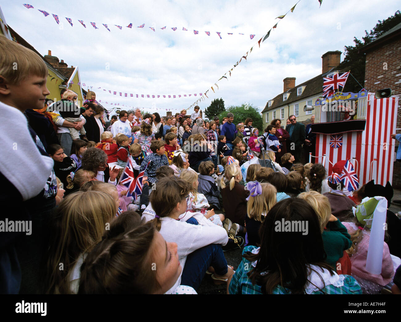 Enfants foule autour d'un Punch et Judy show lors d'une fête de rue d'été dans le village de Suffolk Boxford Banque D'Images