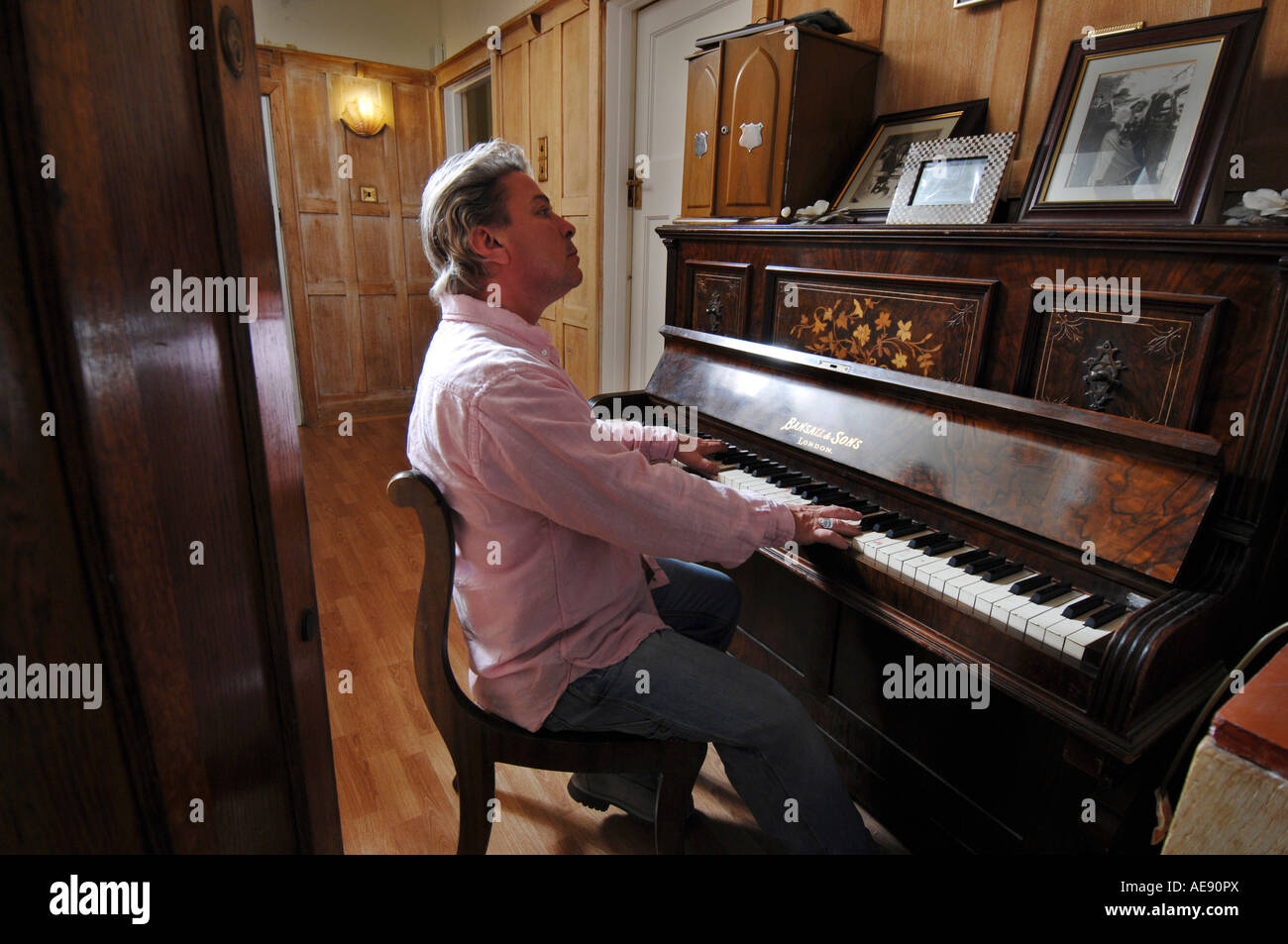 Ex-pop star Bucks Fizz jouer du piano à la maison Banque D'Images