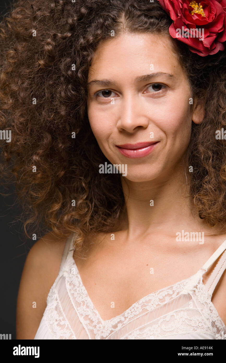 Close up of Hispanic woman smiling with flower in hair Banque D'Images