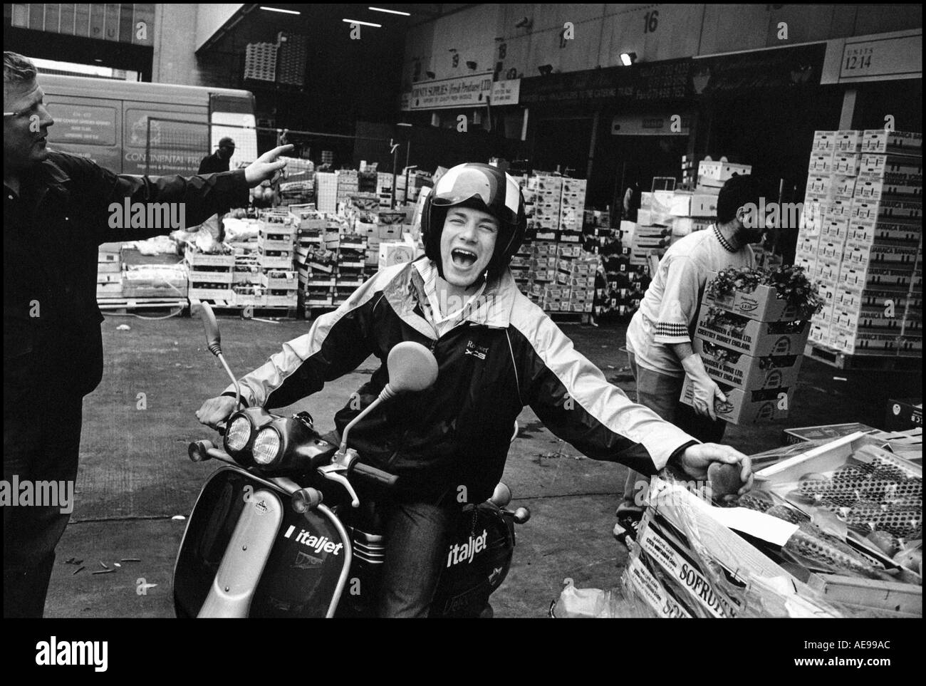 Chef Jamie Oliver TV rire et vérifier l'achat de fruits et légumes à Borough Market sur son scooter. Banque D'Images