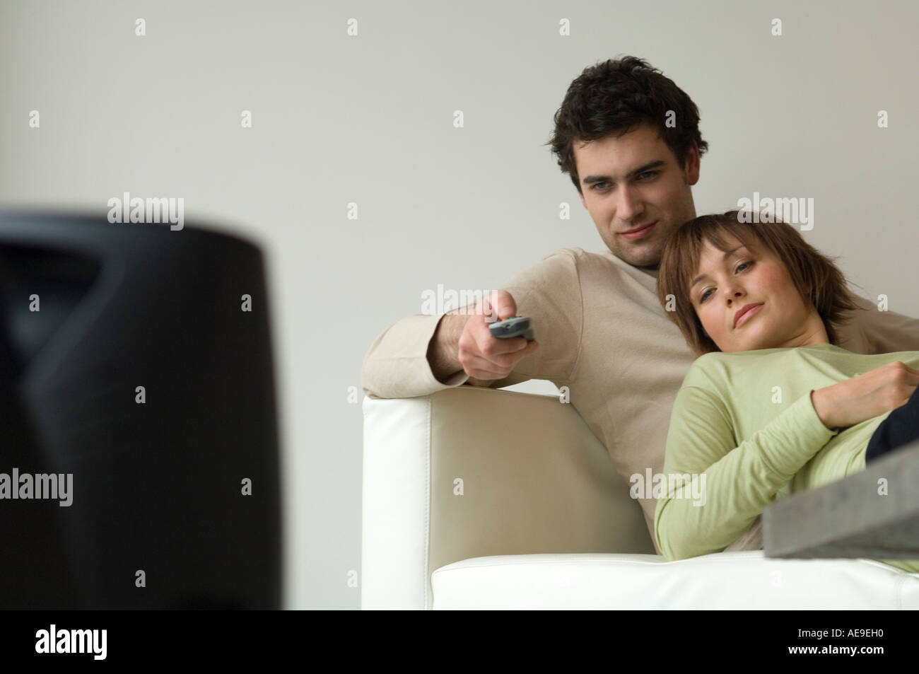 Couple allongé sur un canapé, regarder la télévision Banque D'Images