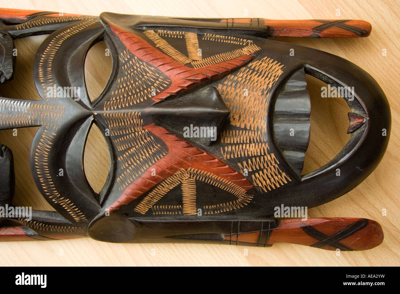 Partie inférieure d'un masque de visage en bois africain de Maasai Mare.Sculpté dans du bois coloré noir et rouge avec des marques marron-jaune ornementées. Banque D'Images