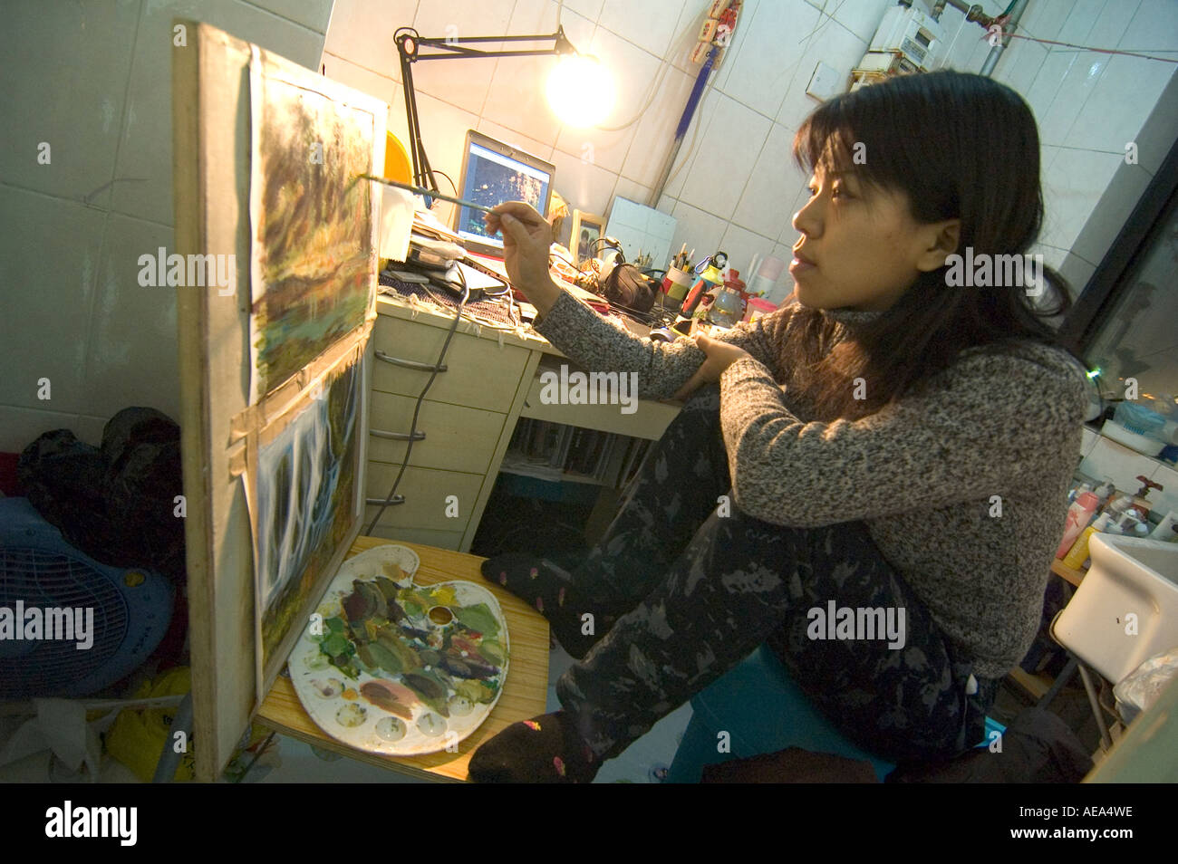 Une jeune fille chinoise en étudiant la peinture arts dans son petit dortoir de l'université de Pékin, Chine Banque D'Images