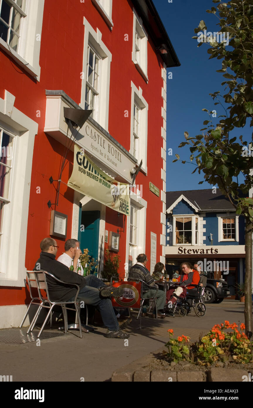 Les gens assis au soleil à l'extérieur de l'hôtel Castle pub Aberaeron Ceredigion Pays de Galles Banque D'Images