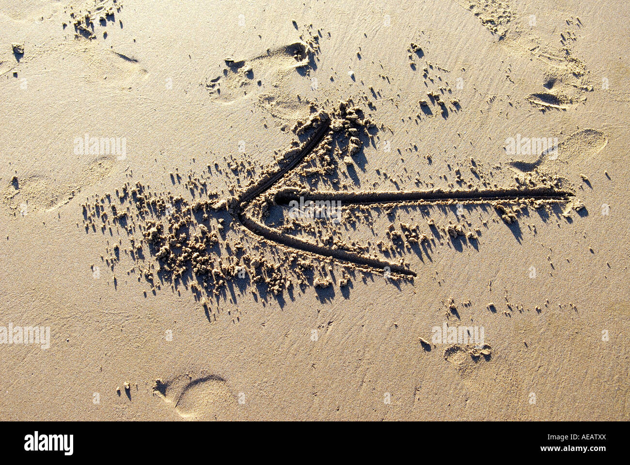 Flèche tracée dans le sable Banque D'Images