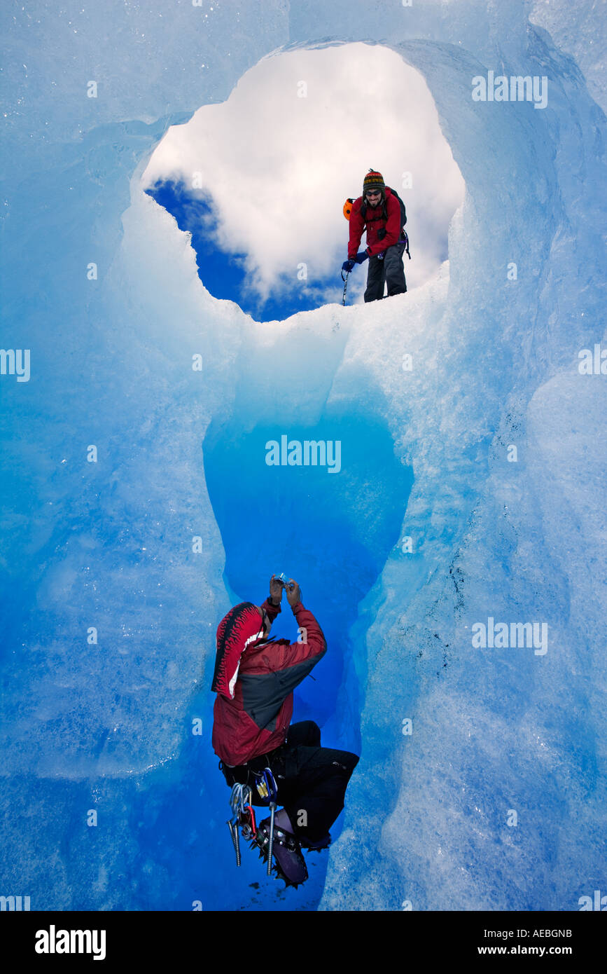 Deux alpinistes en photographiant la grotte de glace de l'autre. Gris Glacier Parc National Torres del Paine au Chili Banque D'Images