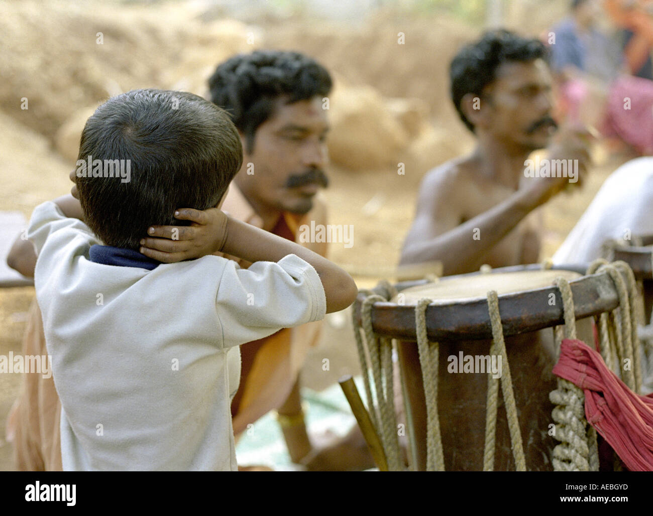 Les percussionnistes traditionnels indiens effectuer au cours d'une cérémonie au temple dans le Kerala, un garçon de ferme ses oreilles à cause du son bruyant Banque D'Images