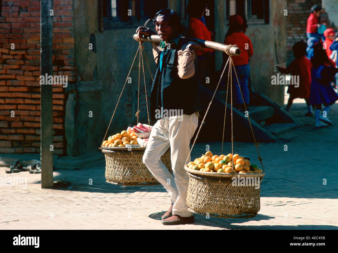 Vendeur de fruits portant des fruits dans des paniers sur l'épaule du Népal Bhaktapur palan Banque D'Images