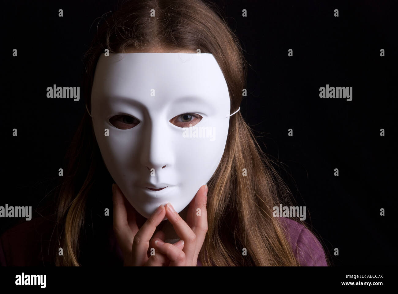 Enfant cachant son visage en portant un masque blanc Uni Banque D'Images