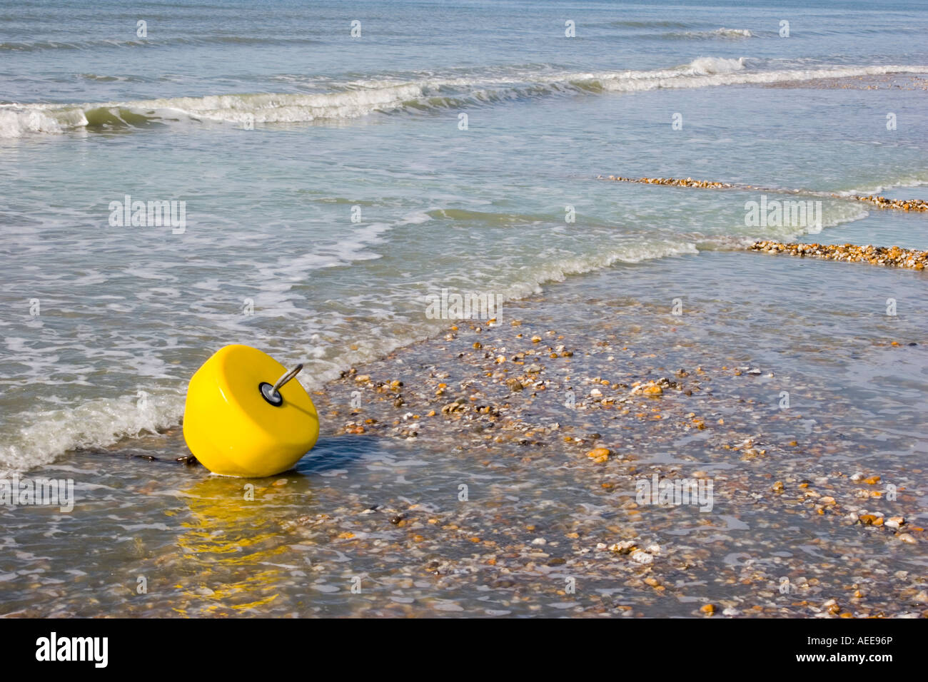 Bouée jaune enchaînés à marée basse se présente comme le débranchement de la mer Banque D'Images