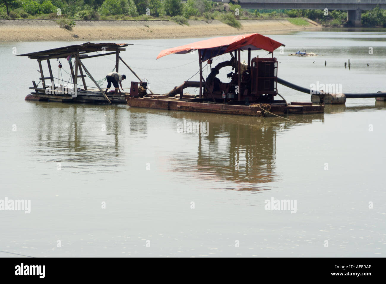 Péniche d'approfondir en suçant riverbed hors du sable et de la verser sur la rivière 'banque'. Banque D'Images