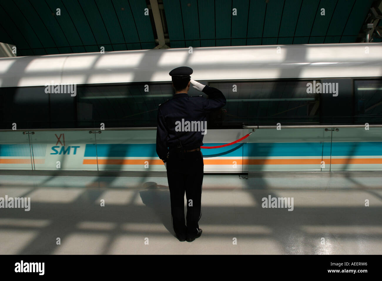 Un garde salue le train à sustentation magnétique Maglev qui transporte les passagers de Longyang Lu gare à l'aéroport de Pudong Banque D'Images
