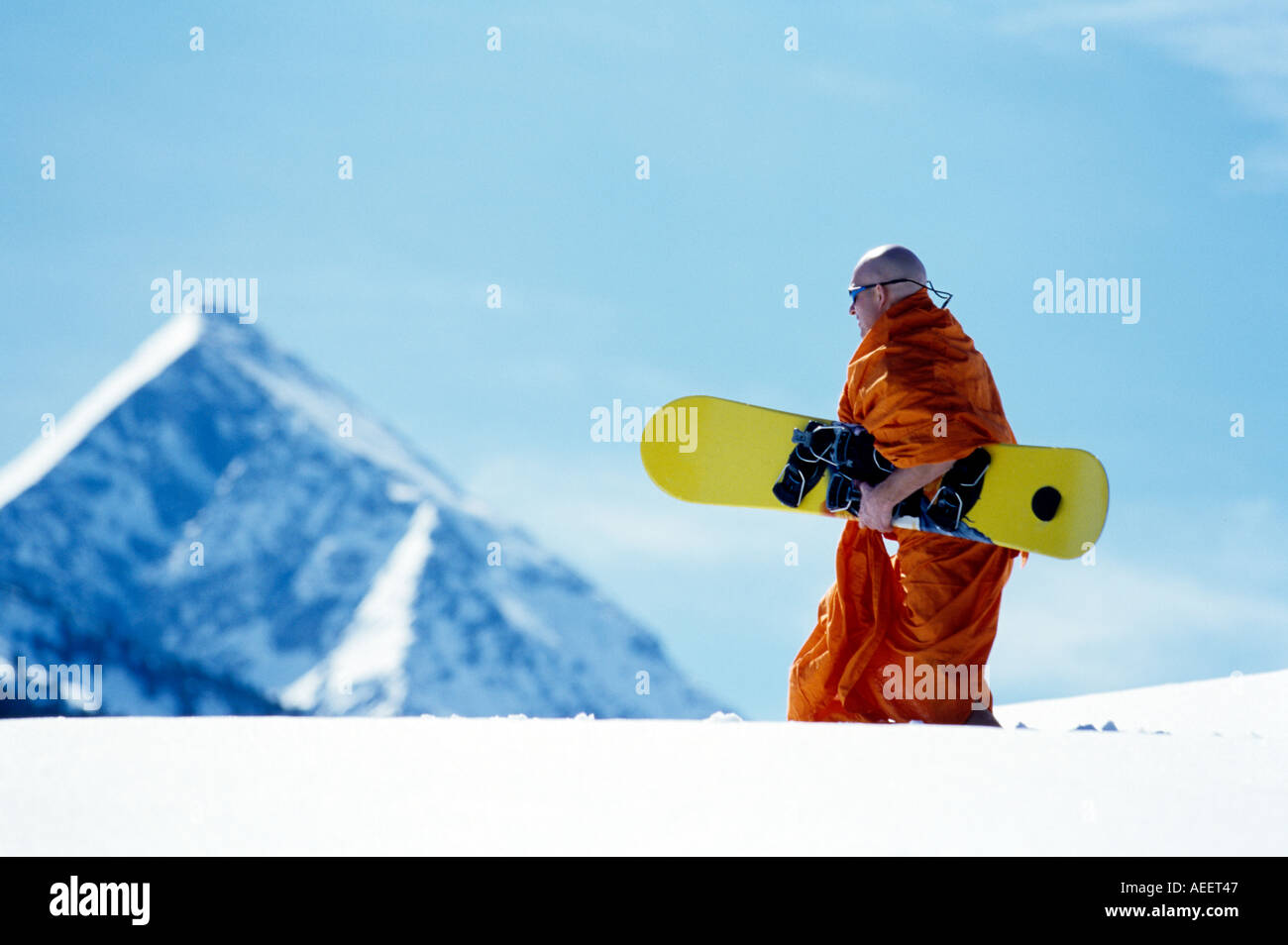 L'homme habillé en moine transportant des neiges dans paysage alpin Banque D'Images