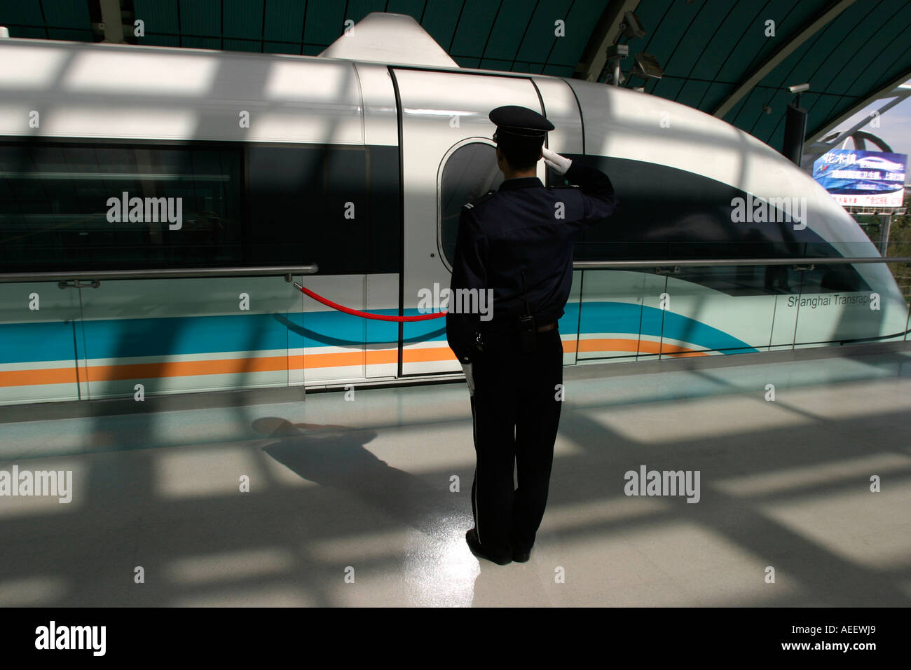 Un garde salue le train à sustentation magnétique Maglev qui transporte les passagers de Longyang Lu gare à l'aéroport de Pudong Banque D'Images