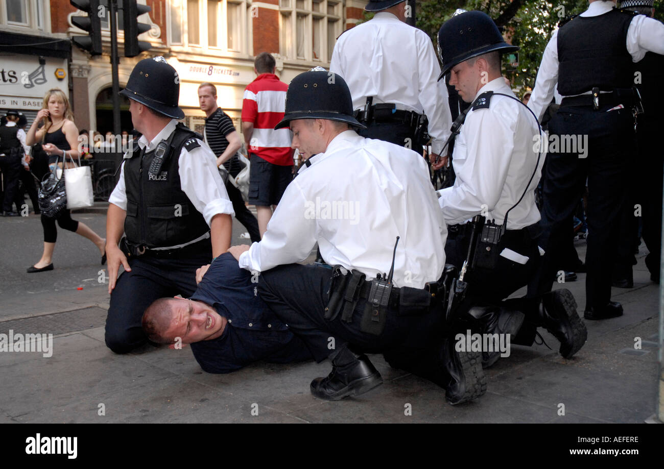 Tenir les agents de police et l'arrestation de menottes jeune fan de football centre de Londres après avoir perdu l'Angleterre Coupe du Monde 2006. Banque D'Images
