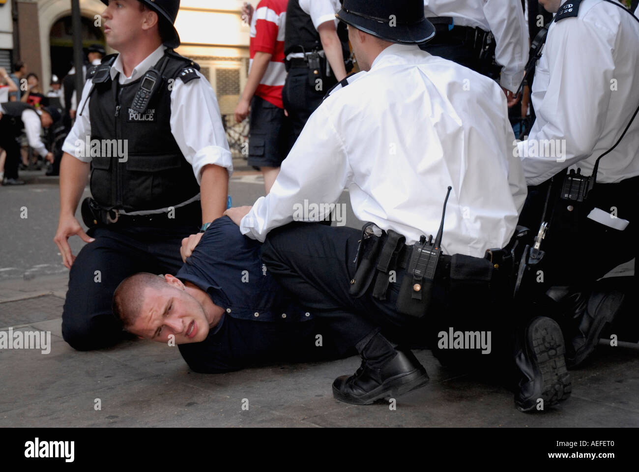 Tenir les agents de police et l'arrestation de menottes jeune fan de football centre de Londres après avoir perdu l'Angleterre Coupe du Monde 2006. Banque D'Images