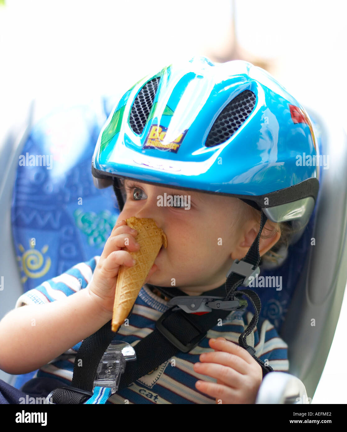 Bébé avec casque et ice-cream cone dans un siège pour enfant Banque D'Images