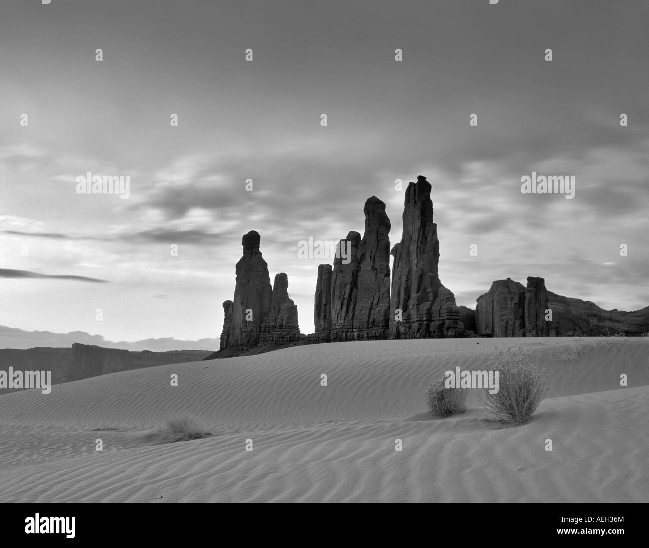 Dunes de sable et Totem rock formation au lever de Monument Valley Arizona Banque D'Images